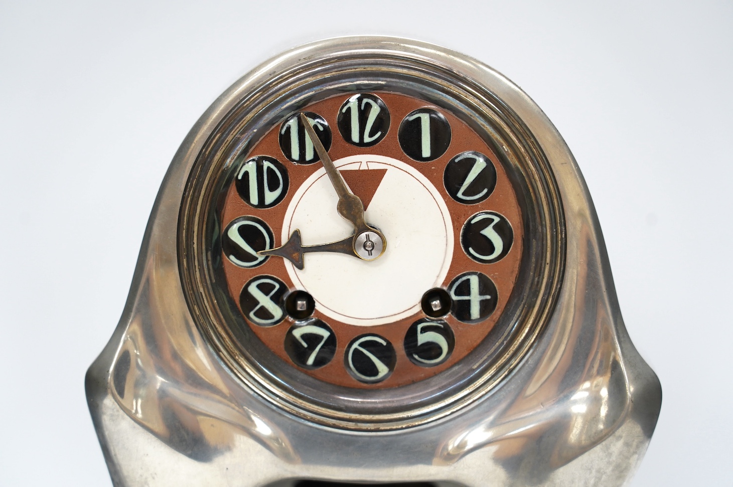 An Orivit Secessionist design pewter mantel clock, c.1905, enamelled dial and French drum shaped movement, 35cm high x 20cm at base. Condition - good